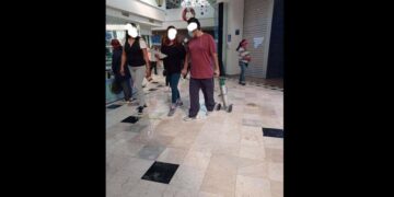 Hombre pasea por centro comercial con su tanque de oxígeno